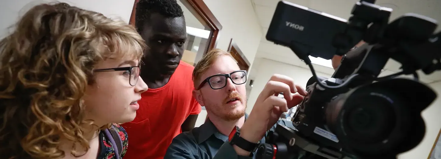 Student 工作ing with a video camera with a professor